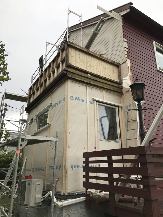 Etterisolert vegg med ny vindsperre under arbeid