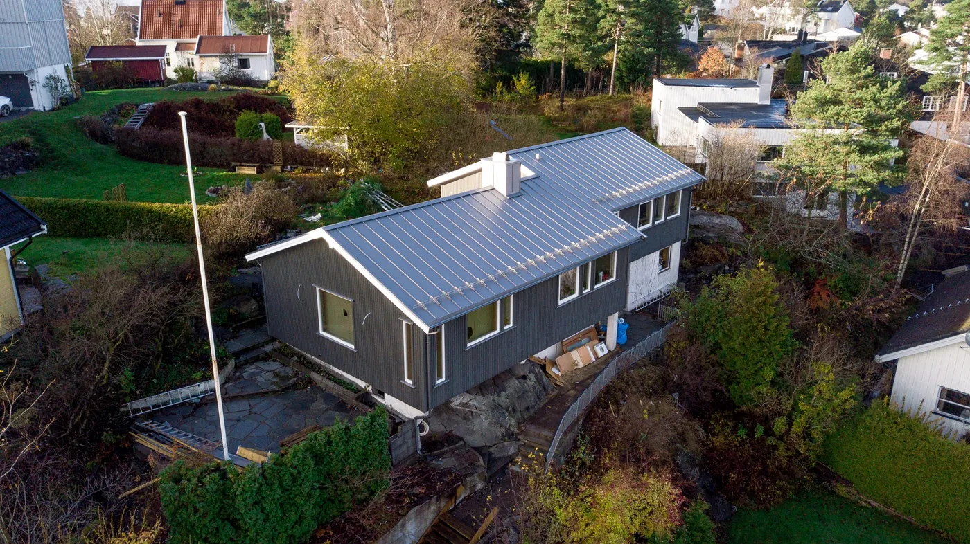 Etter: boligen på Ekeberg med ny mørk kledning og nye vinduer, sett fra drone