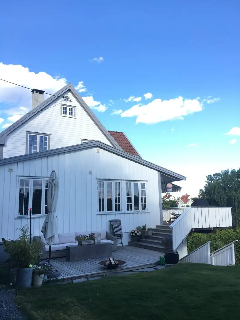 Boligen med ny, hvit kledning og nye vinduer